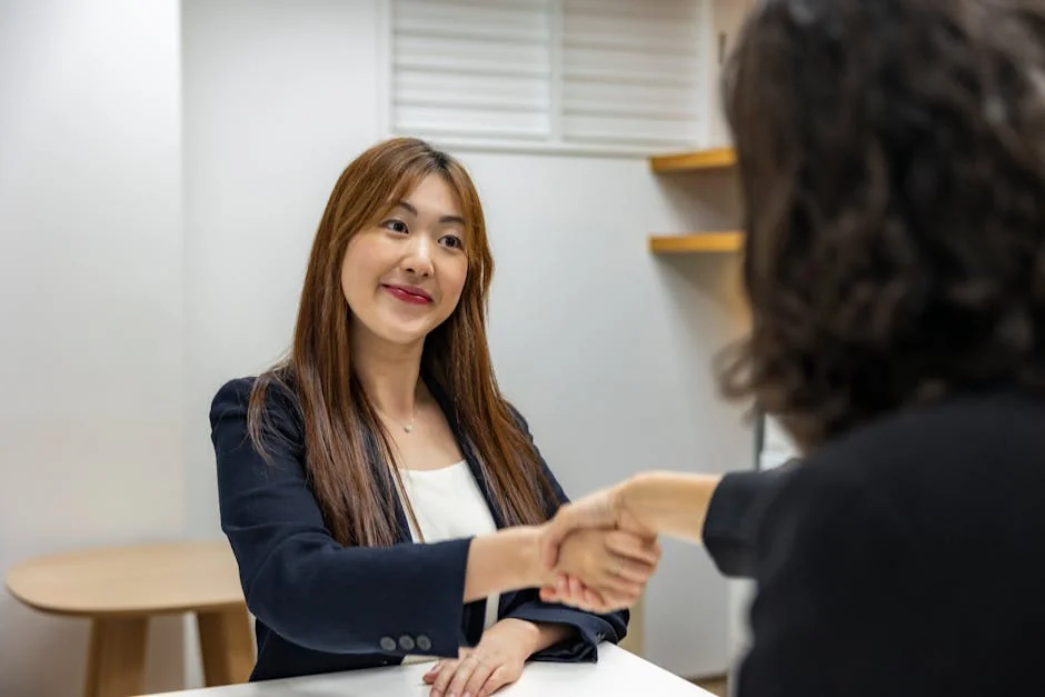 Businesswoman in professional attire shaking hands with recruiter in an office setting. - from unemployed to hired in 2 weeks